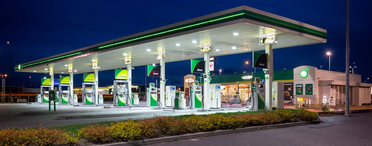 A bp petrol and EV charging station illuminated at night